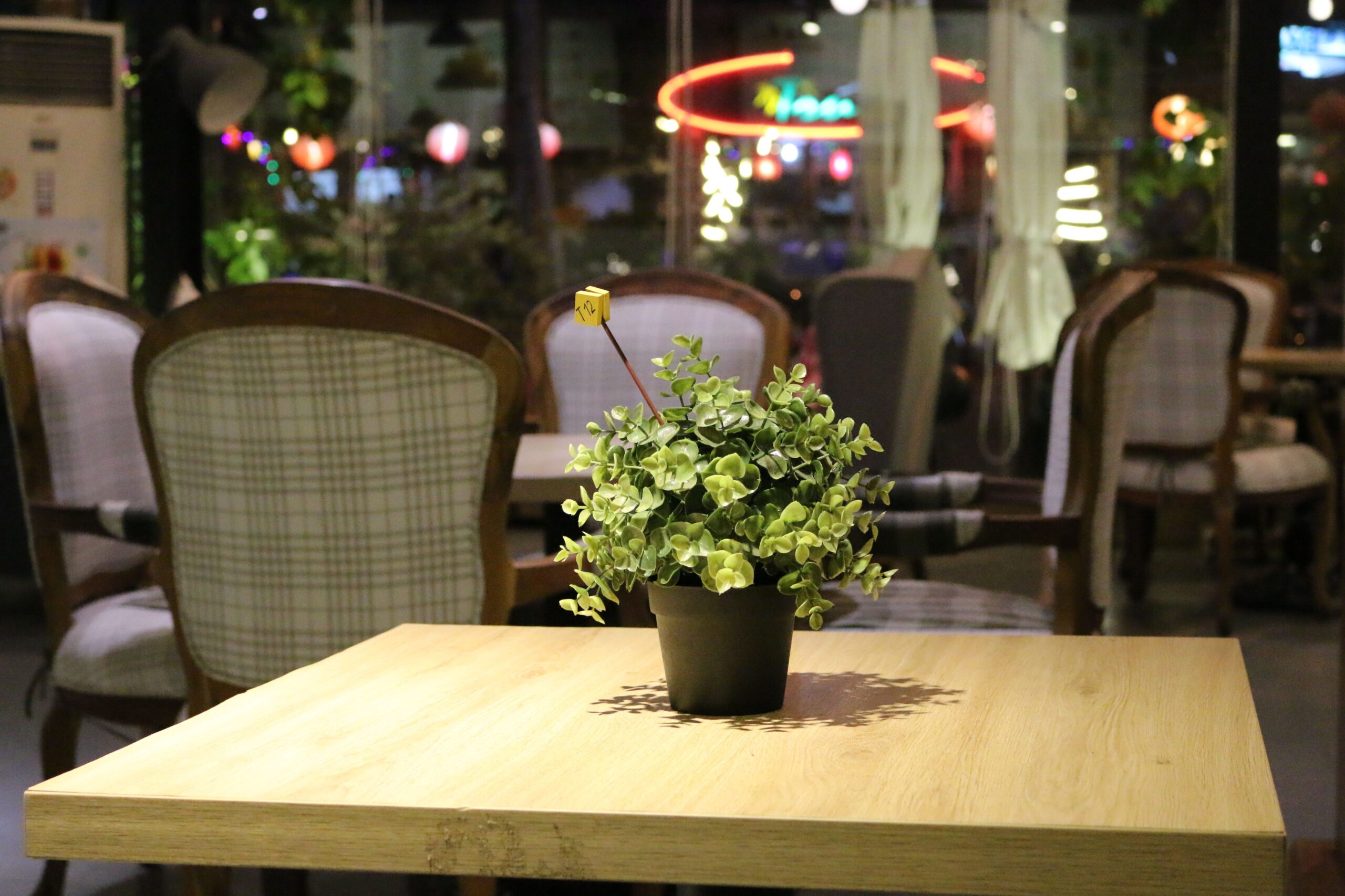 夜のカフェの落ち着いたテーブル席と観葉植物